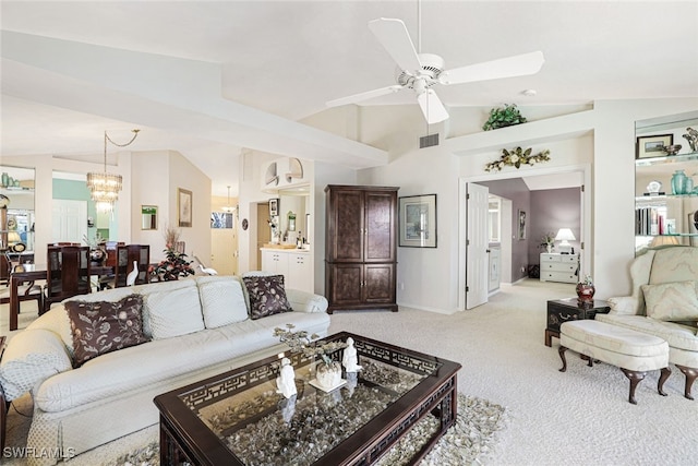 carpeted living room with ceiling fan and high vaulted ceiling