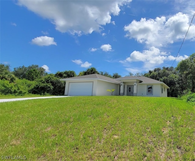 ranch-style home featuring a front yard, driveway, an attached garage, and stucco siding