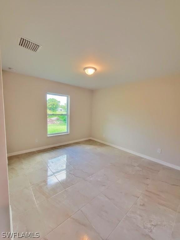 empty room with baseboards and visible vents