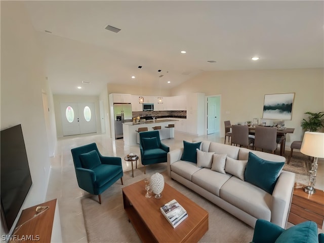 living area with lofted ceiling, visible vents, and recessed lighting