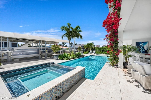 outdoor pool featuring a boat dock, a patio area, and an in ground hot tub