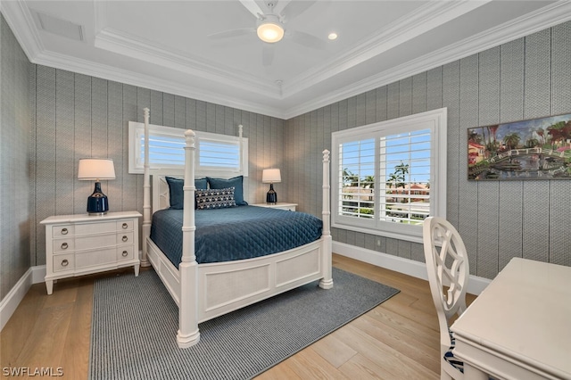 bedroom featuring baseboards, wood finished floors, and crown molding