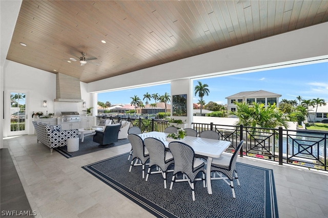 view of patio with ceiling fan, outdoor dining area, exterior kitchen, and area for grilling