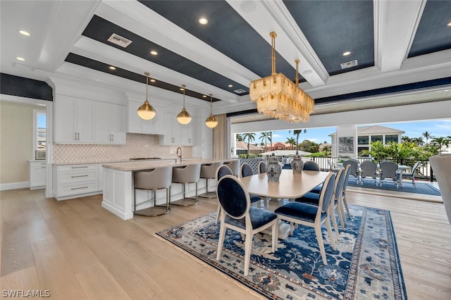 dining room featuring visible vents, beam ceiling, coffered ceiling, and light wood-style flooring