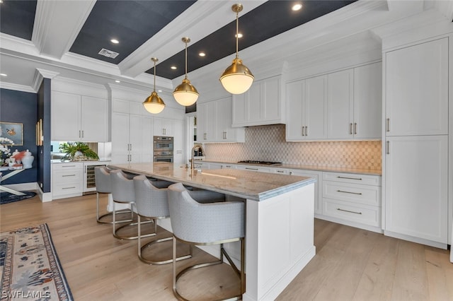 kitchen featuring wine cooler, crown molding, light wood-style flooring, double oven, and white cabinetry