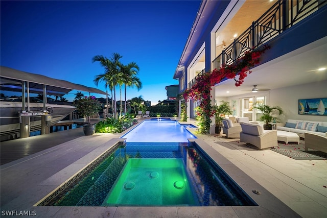 pool featuring an in ground hot tub, a patio area, ceiling fan, and an outdoor hangout area