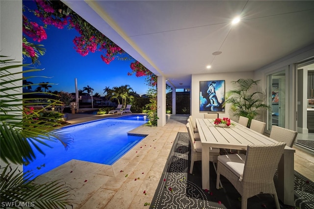 outdoor pool with a patio area and outdoor dining space