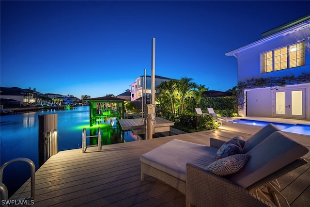 wooden deck with french doors, a boat dock, a water view, and an outdoor pool