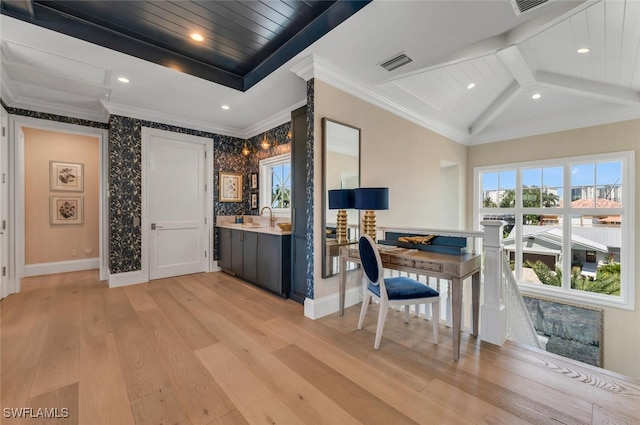 interior space with vaulted ceiling with beams, visible vents, baseboards, ornamental molding, and light wood finished floors