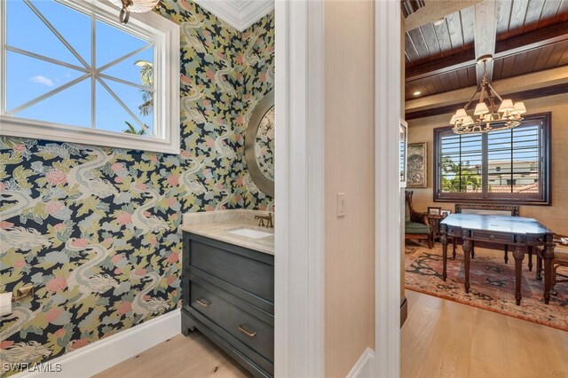 bathroom featuring wood ceiling, an inviting chandelier, beam ceiling, and wallpapered walls