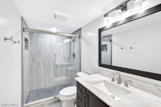 bathroom with vanity, toilet, and a shower with shower door