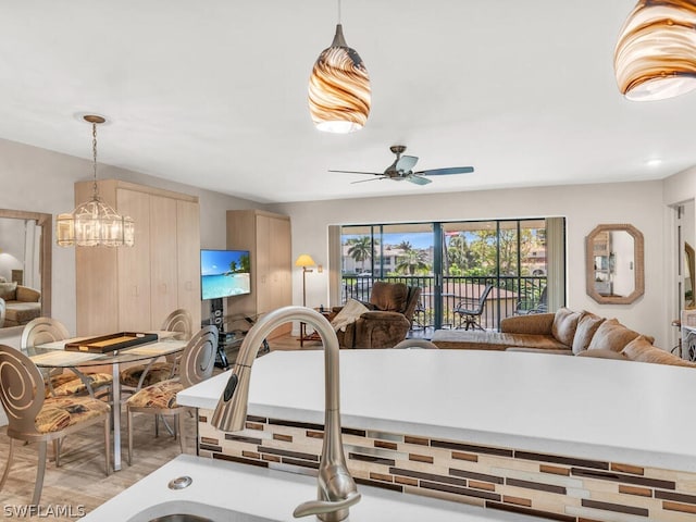 interior space with light brown cabinetry, decorative light fixtures, and ceiling fan with notable chandelier