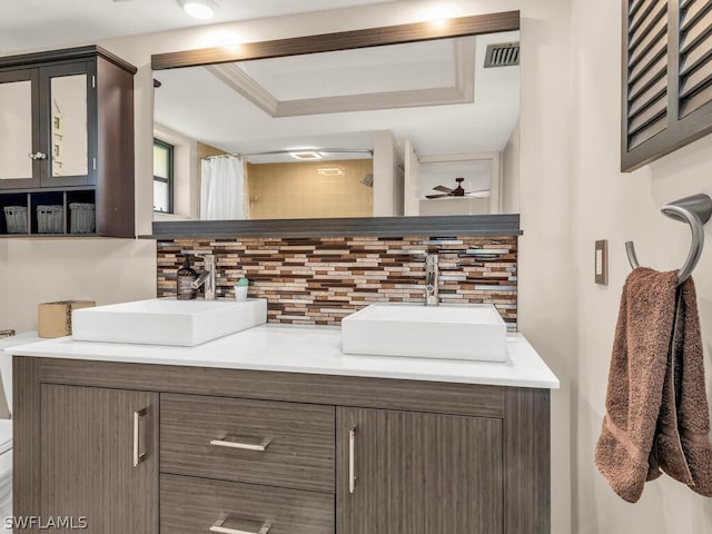 bathroom with backsplash, toilet, a raised ceiling, and large vanity