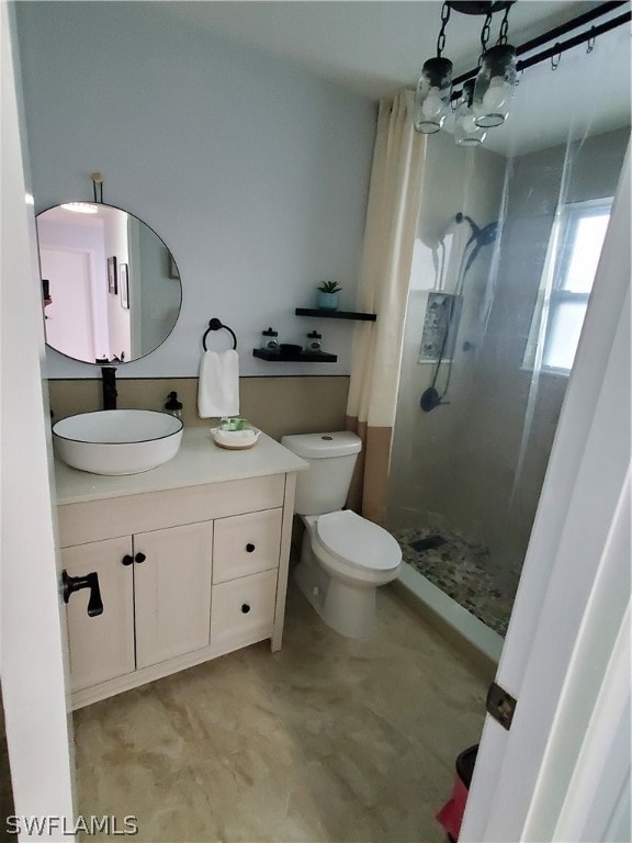 bathroom featuring tiled shower, vanity, toilet, and a chandelier