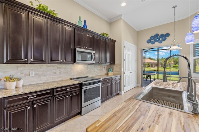 kitchen with appliances with stainless steel finishes, decorative light fixtures, sink, and dark brown cabinets