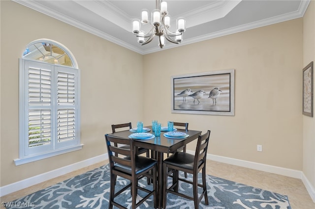 dining room with crown molding, a tray ceiling, and a chandelier