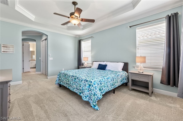 carpeted bedroom with ceiling fan, ornamental molding, and a raised ceiling