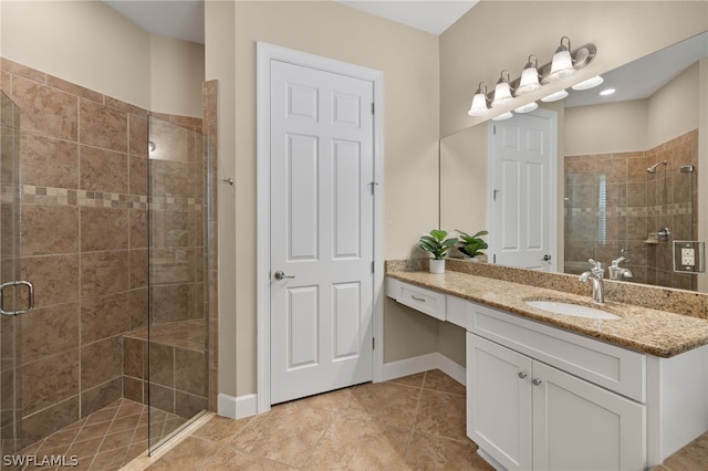 bathroom with tile patterned flooring, vanity, and walk in shower