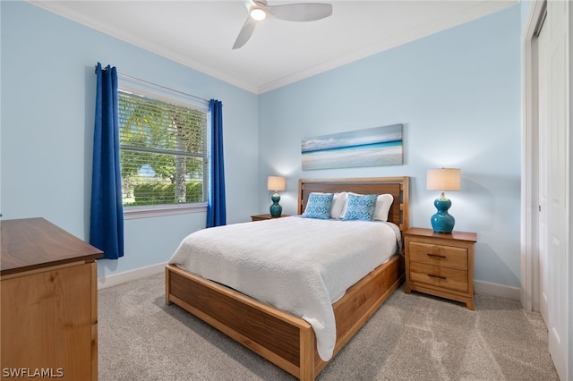 carpeted bedroom featuring crown molding, ceiling fan, and a closet