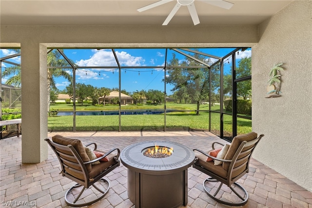 sunroom / solarium with ceiling fan and a water view