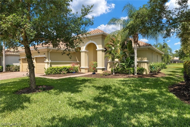 mediterranean / spanish home with a garage and a front yard