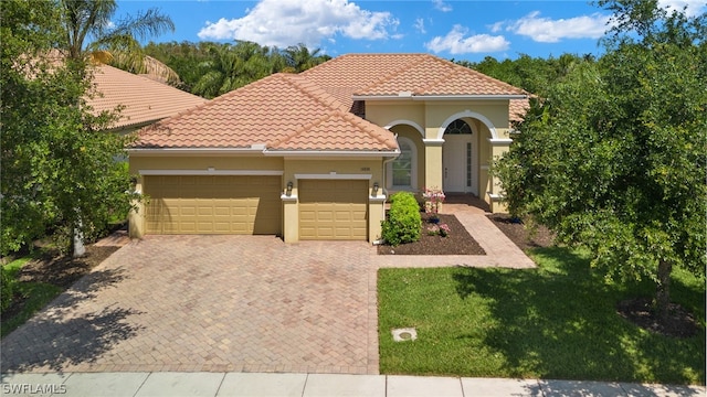 mediterranean / spanish house featuring a garage and a front yard