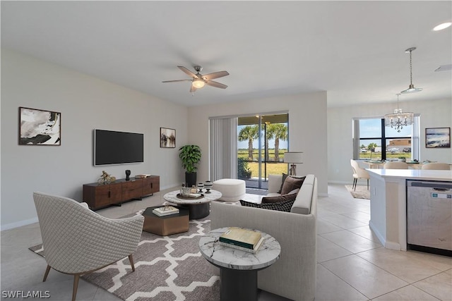 tiled living room with ceiling fan with notable chandelier