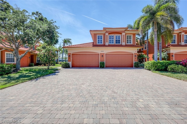 mediterranean / spanish-style home with a front yard and a garage