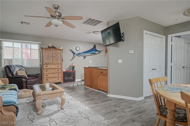 living room featuring ceiling fan and light wood-type flooring