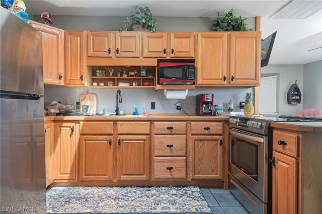 kitchen with sink, light tile flooring, and stainless steel appliances