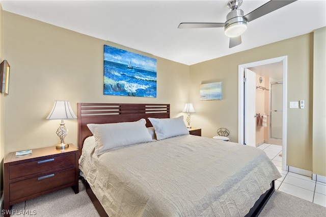 tiled bedroom featuring ceiling fan and ensuite bath