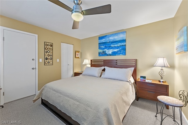 bedroom with ceiling fan, light colored carpet, and a closet