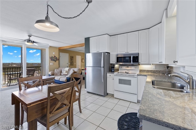 kitchen with pendant lighting, ceiling fan, stainless steel appliances, sink, and white cabinetry