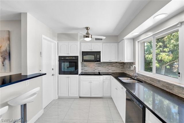 kitchen with decorative backsplash, white cabinets, black appliances, and sink