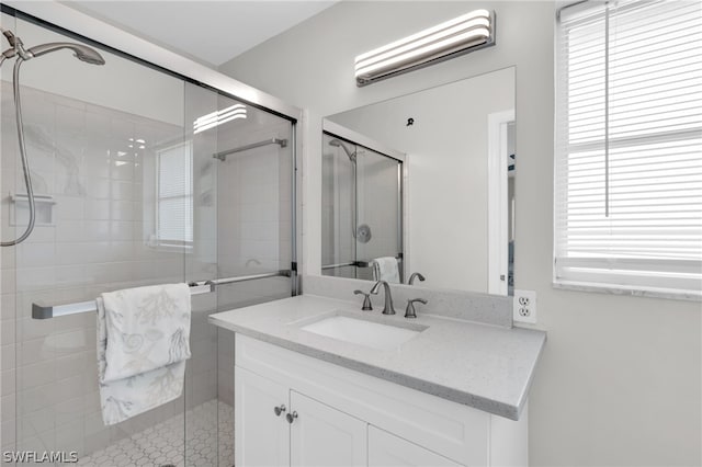 bathroom featuring vanity and a shower with shower door