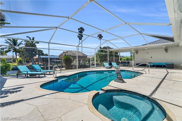 view of pool with an in ground hot tub, a patio, and glass enclosure