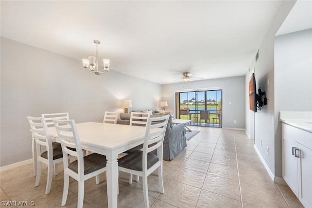 tiled dining space with ceiling fan with notable chandelier