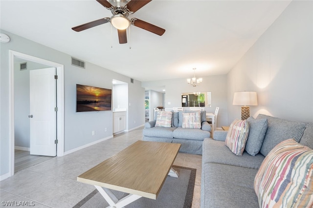 tiled living room with ceiling fan with notable chandelier