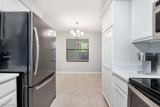 kitchen with hanging light fixtures, appliances with stainless steel finishes, light tile floors, white cabinets, and a chandelier