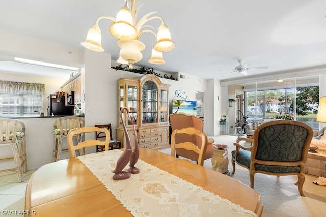 dining space with ceiling fan with notable chandelier