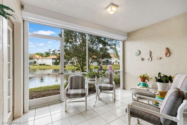 sunroom featuring a water view