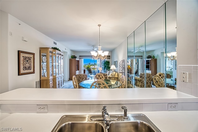 kitchen featuring pendant lighting, sink, and an inviting chandelier