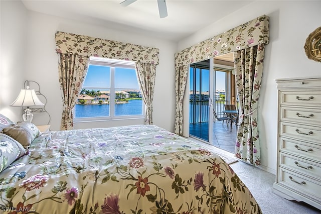 carpeted bedroom featuring ceiling fan, a water view, and access to outside