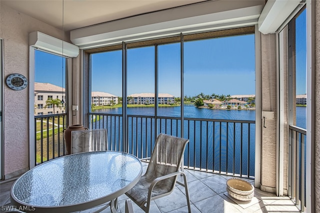 sunroom featuring a water view