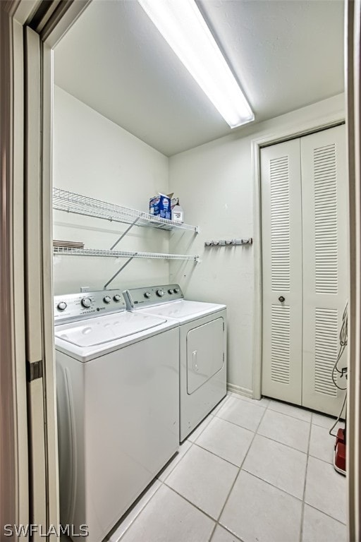 washroom featuring light tile patterned flooring and washer and dryer