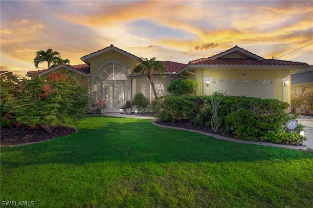 mediterranean / spanish house featuring a lawn and a garage