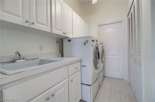 laundry room with cabinets, separate washer and dryer, light hardwood / wood-style floors, and sink