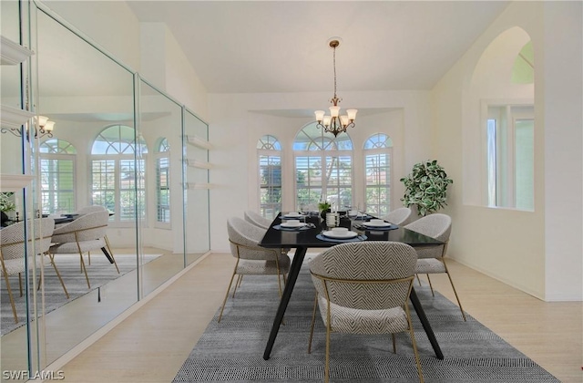 dining space featuring light wood-type flooring and an inviting chandelier