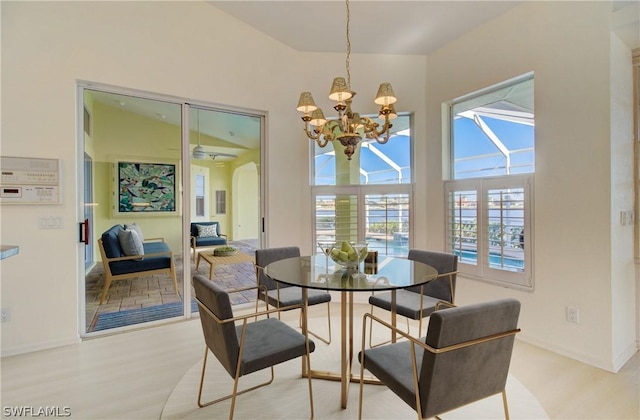 dining room with a notable chandelier, light wood-type flooring, and lofted ceiling