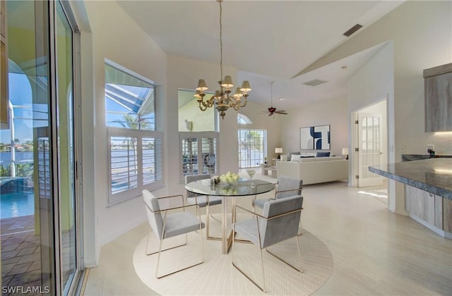 dining area with ceiling fan with notable chandelier and vaulted ceiling